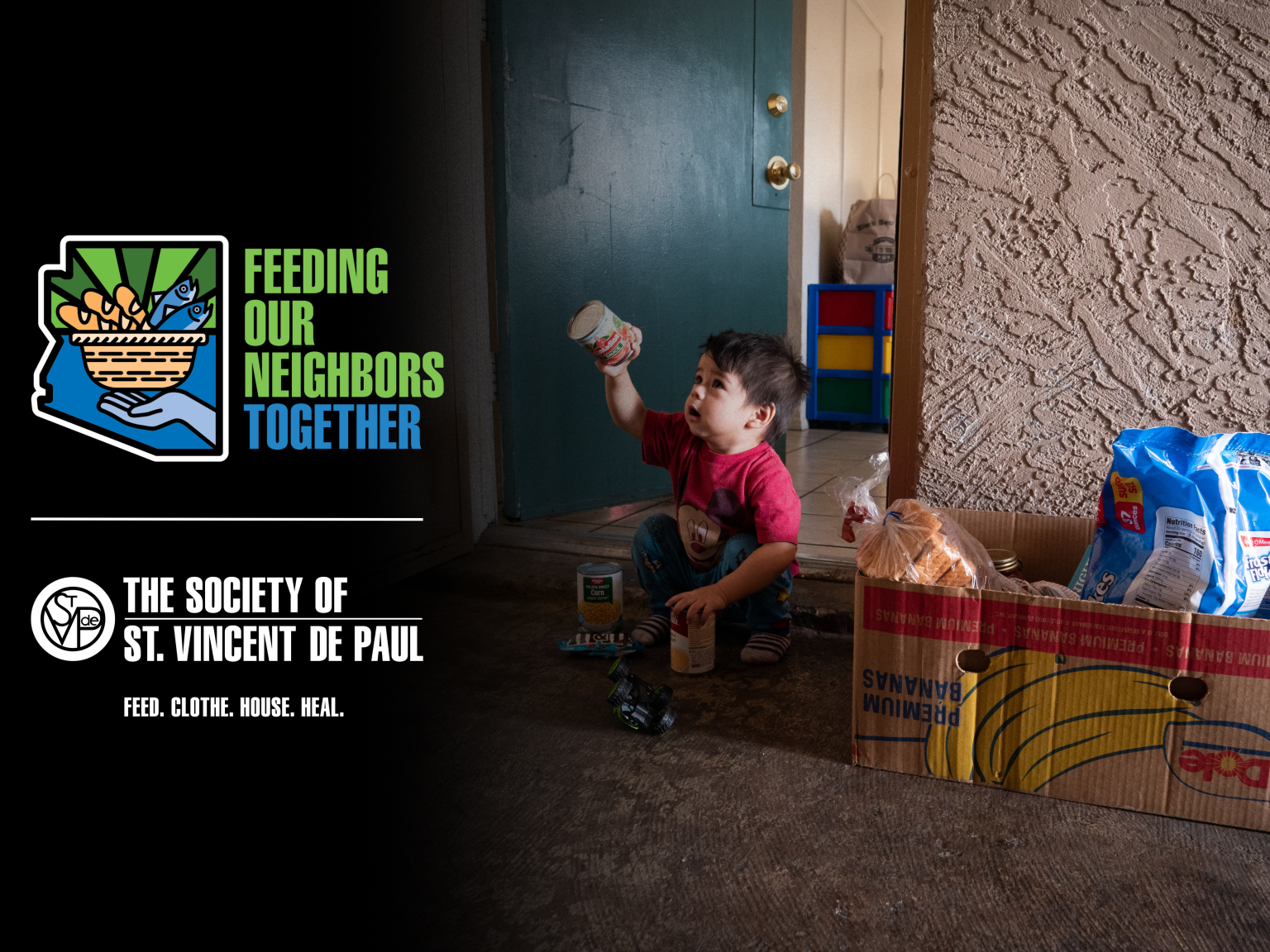 Boy sitting outside his house with a food box