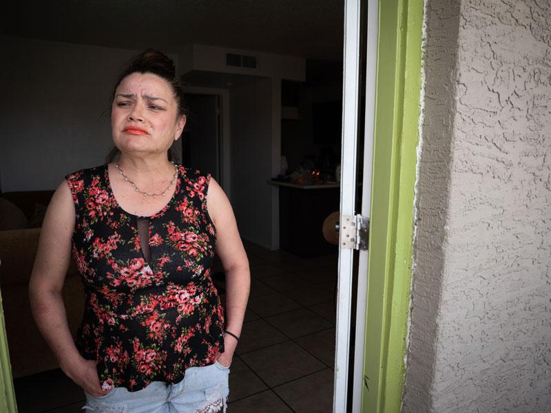On a recent home visit, a mother affected economically by the COVID-19 pandemic looks worriedly from her doorway, unsure what the future may bring.