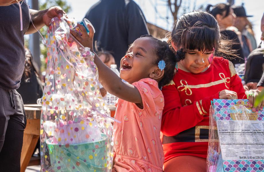 A girl grins at a toy she received in an Easter Basket from SVdP.