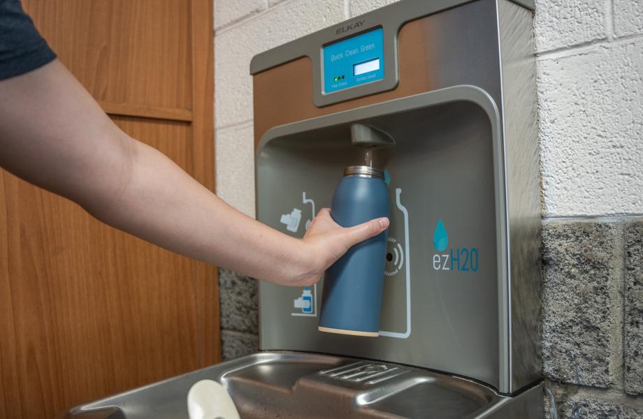 A woman fills a bottle at one of SVdP's refilling stations.