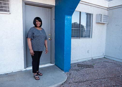 Woman standing outside the door of her apartment