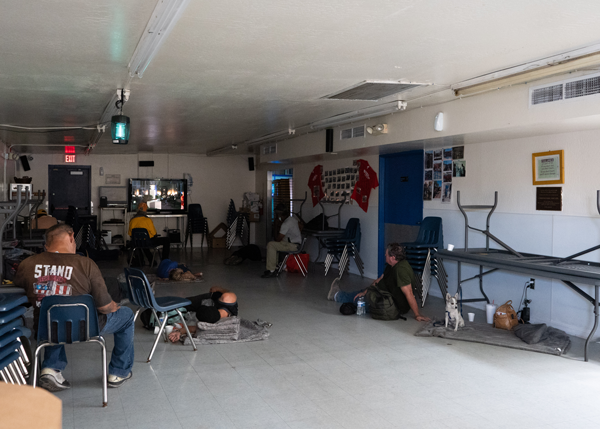 Men sitting in a room watching TV