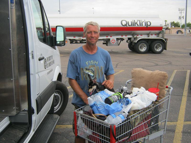 Man standing behind a shopping cart smiling