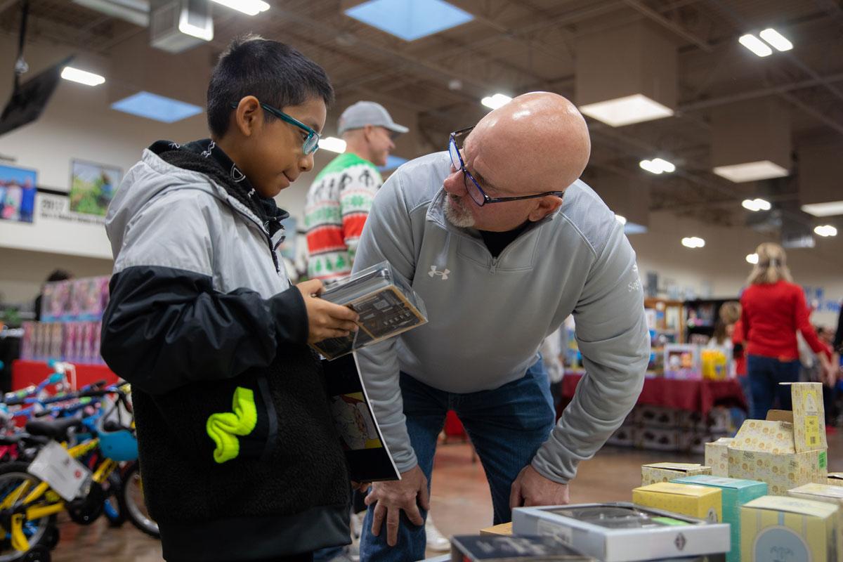 Volunteers, including Jim Golembiewski from Sagicor, help the students pick out the perfect presents.