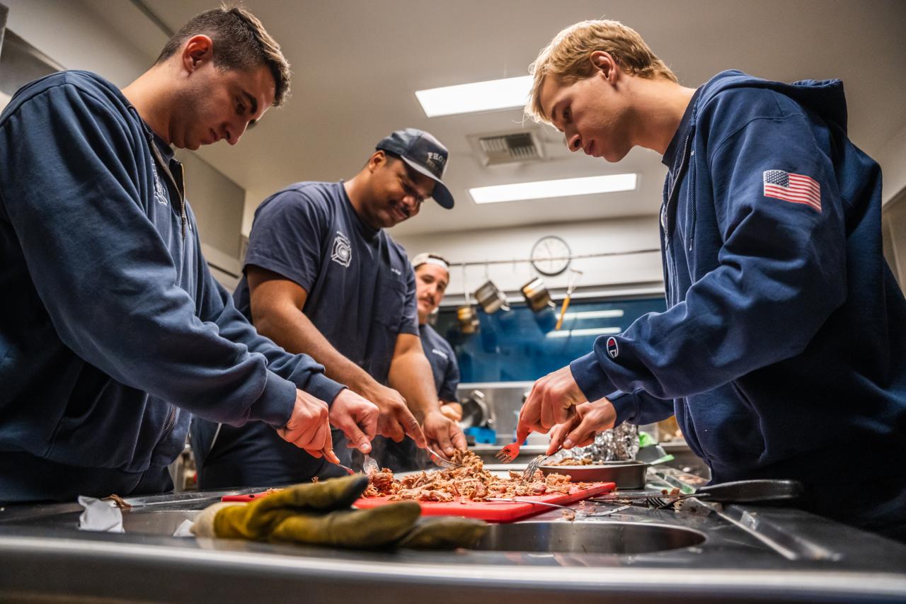 The Laveen firemen prepare pulled pork for the family.