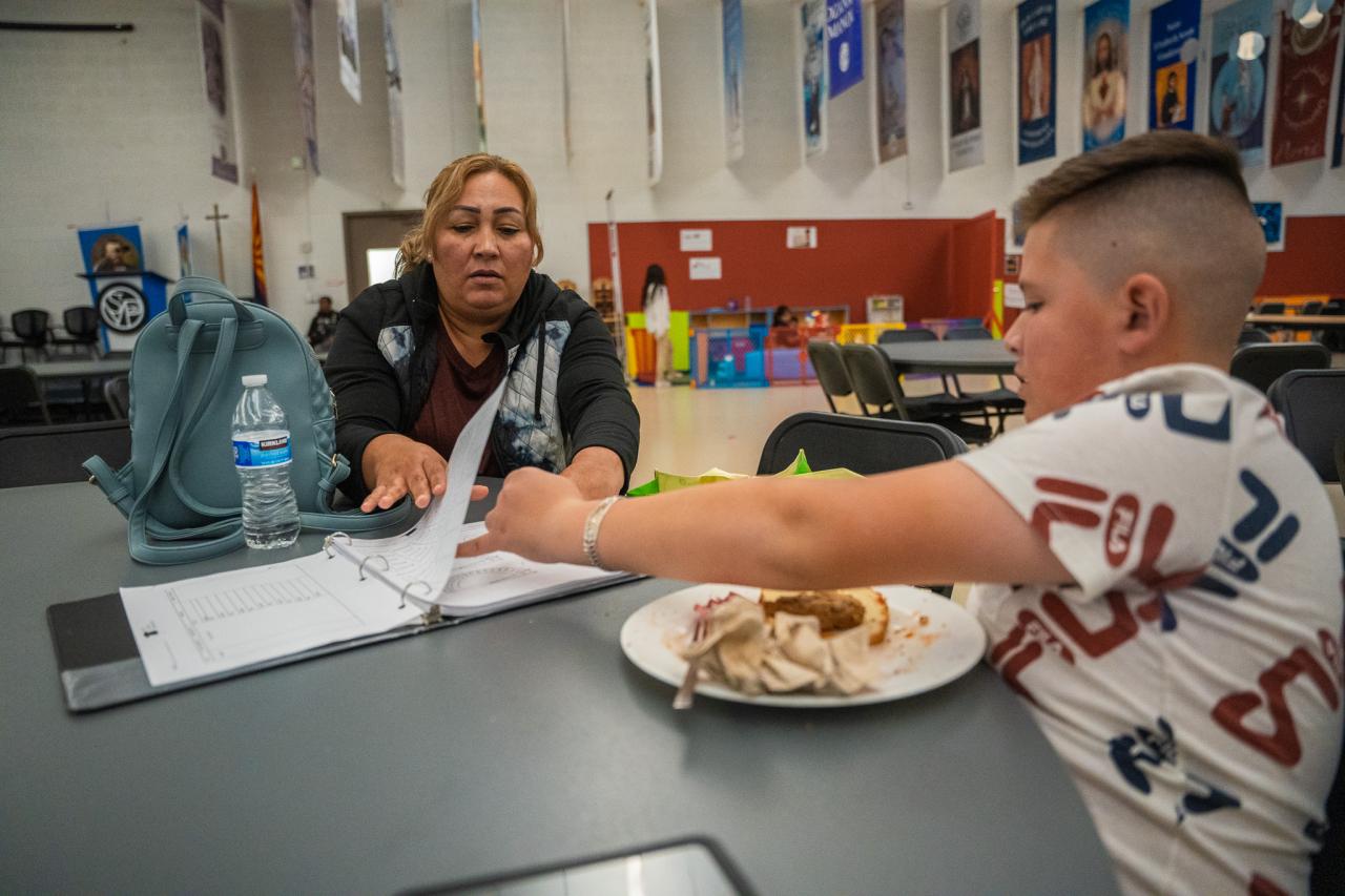 Cruz, Davids mom, helps David look over his homework.