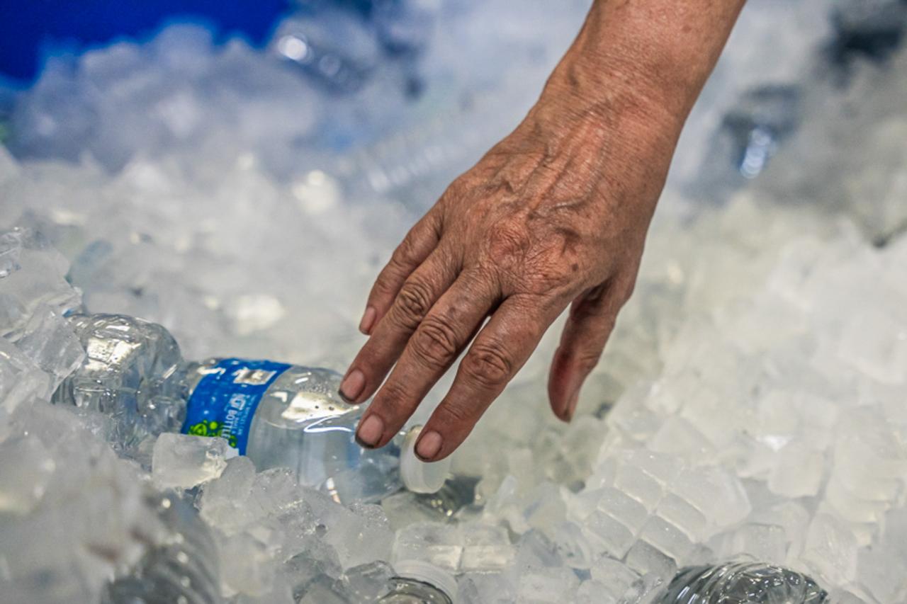 A guest reaches for a water bottle in one of SVdP's Heat Relief locations.