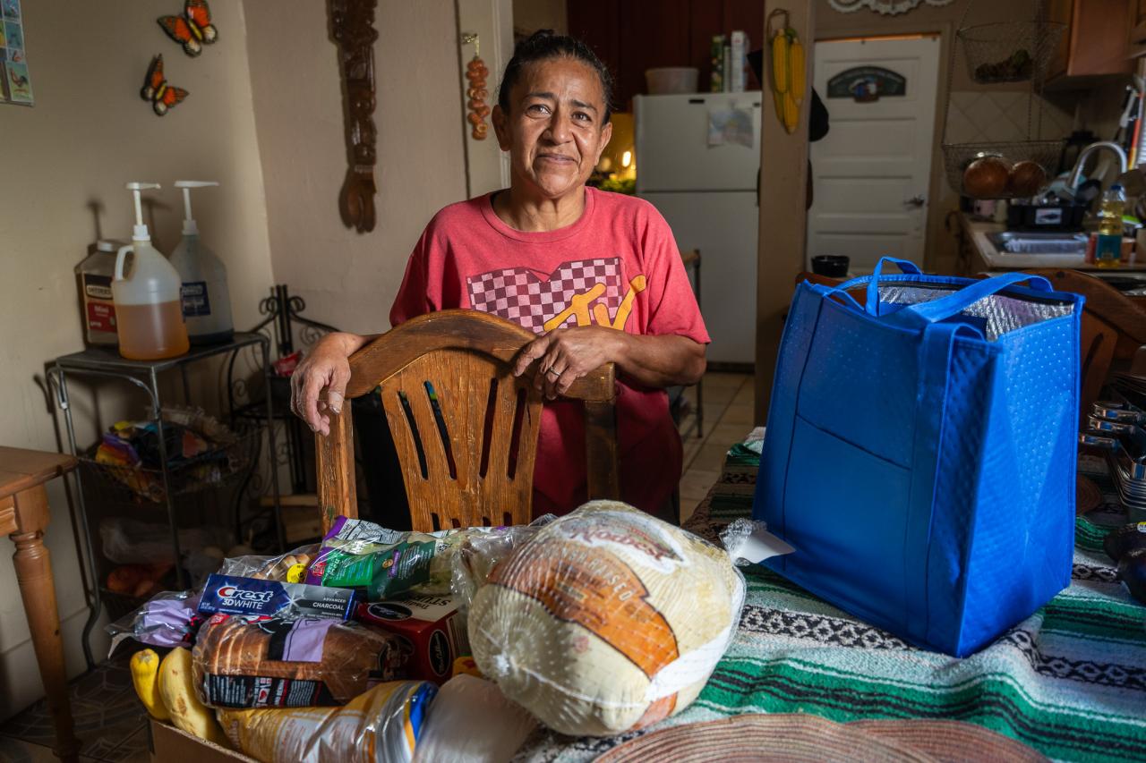 Margarita stands with her food box from SVdP.