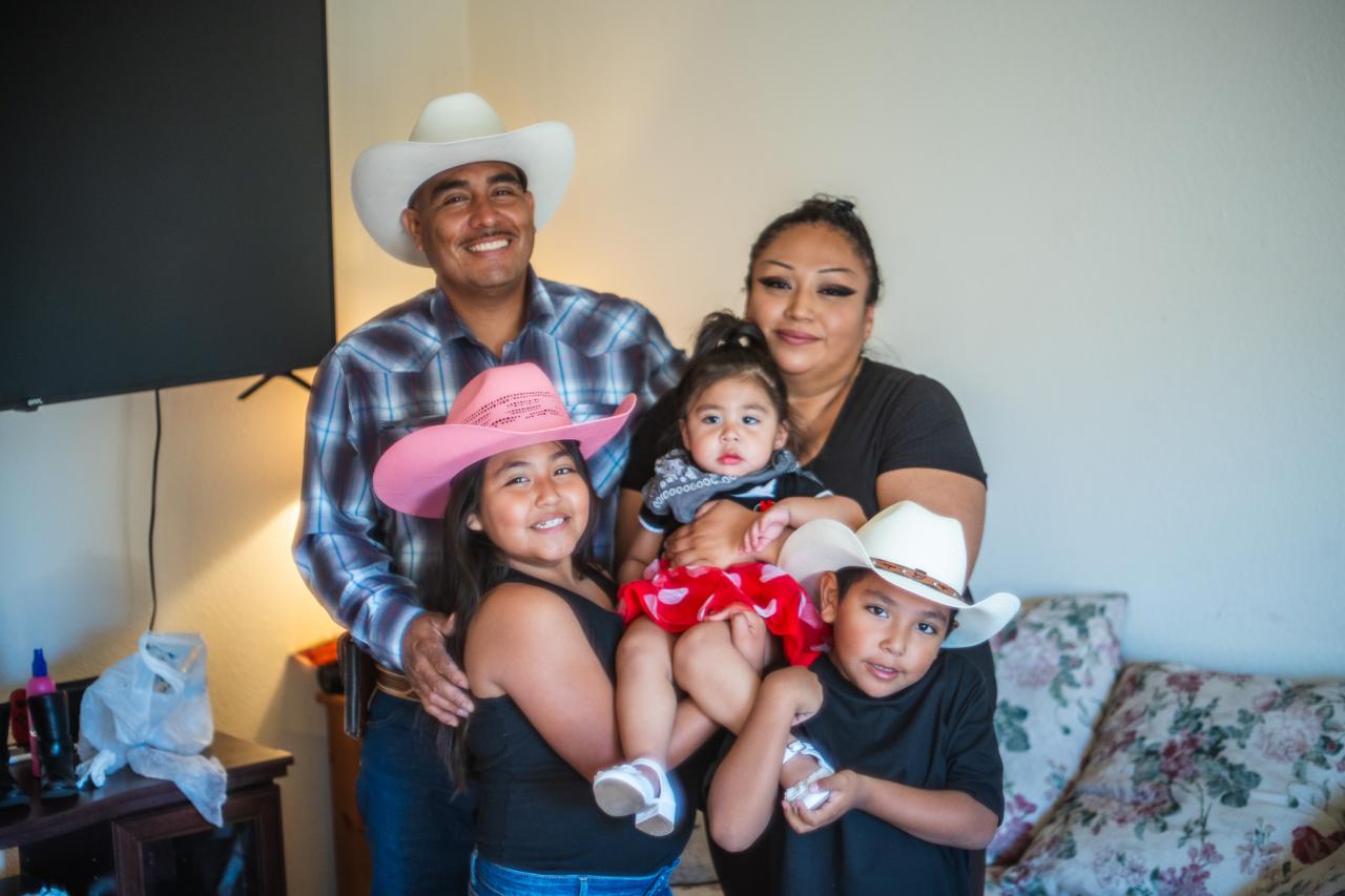 Julio Gastelum and his family stand in their home.