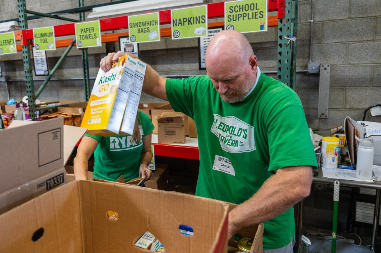 Chuck Carefoot, Ryan Companies' President of the Southwest Region, helps pack a food box in SVdP's Food Reclamation Center.