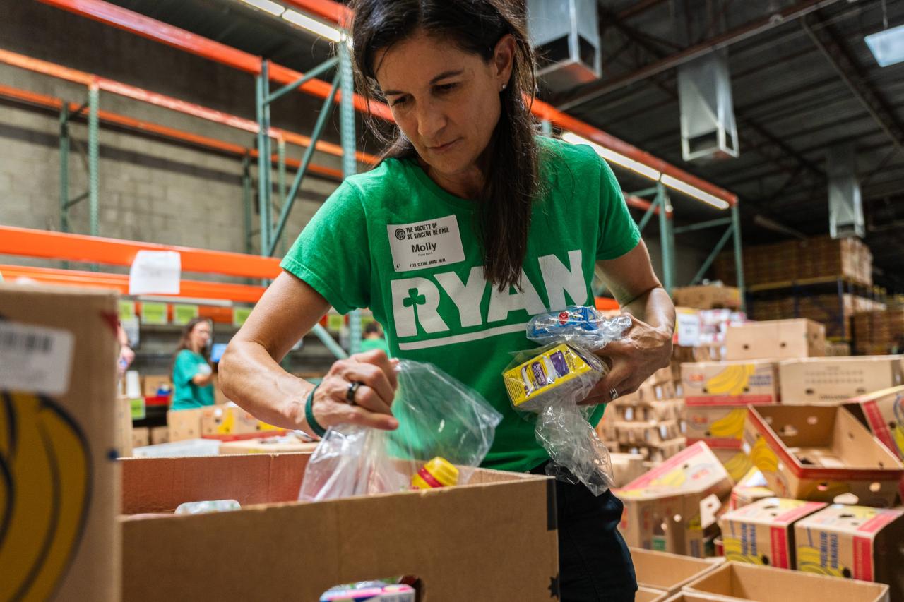 Molly Carson, Ryan Companies' Executive Vice President of the Southwest Region helps pack a food box for families in need at SVdP's Food Reclamation Center.