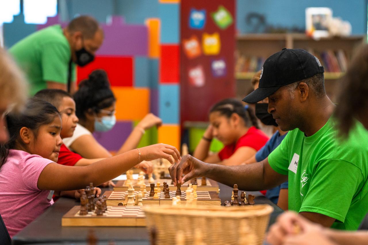 CEO Michael Jones plays chess with a kid in the Dream Center.
