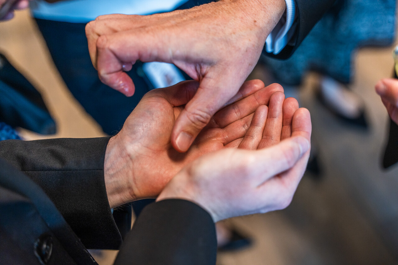 A close up of the blessing of hands of clinic workers and health care volunteers who will serve patients.